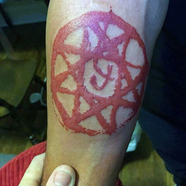 Red ink style cult style forearm tattoo of demonic symbol