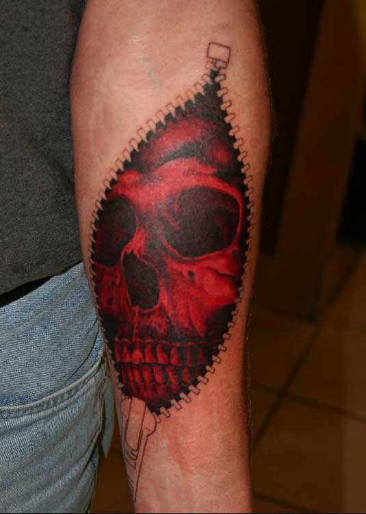 Red skull beneath skin forearm tattoo