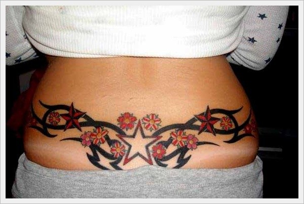 Red star and flowers with black tribal tattoo on lower back