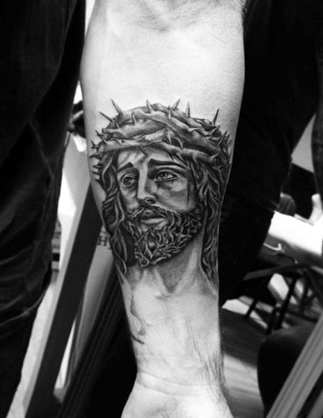 Religious Jesus Christ portrait in crown of thorns tattoo on forearm