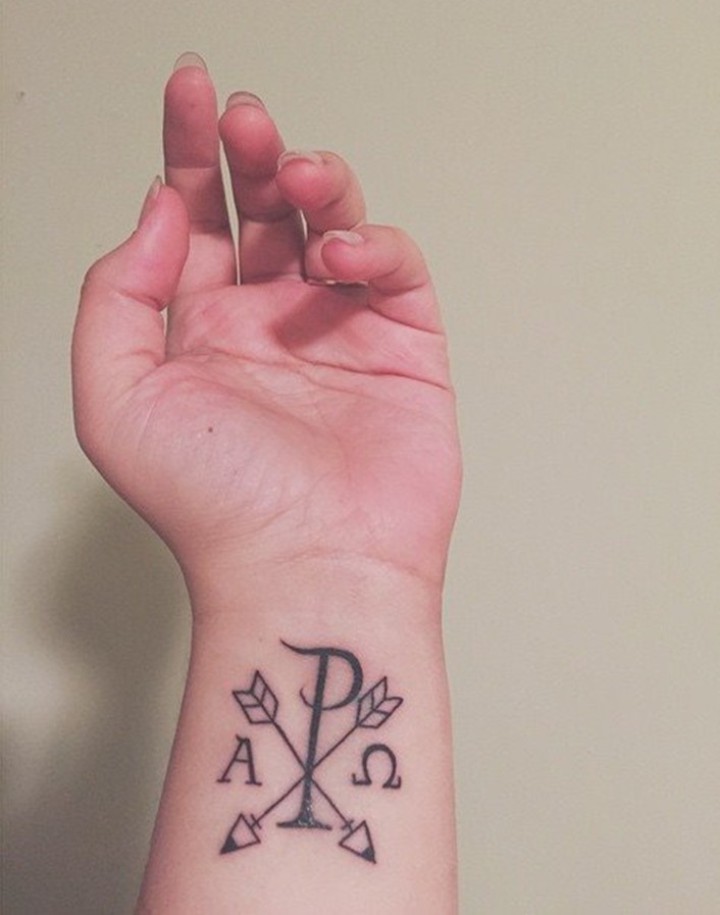 Religiöses Tattoo mit Christus speziellem Monogramm Symbol Chi Rho mit Pfeilen am Handgelenk