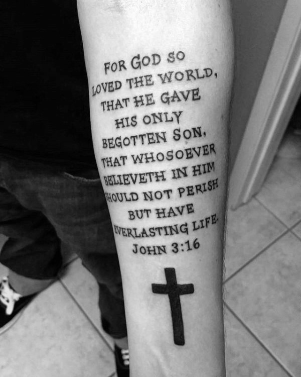 Religious themed black ink forearm tattoo of lettering with cross