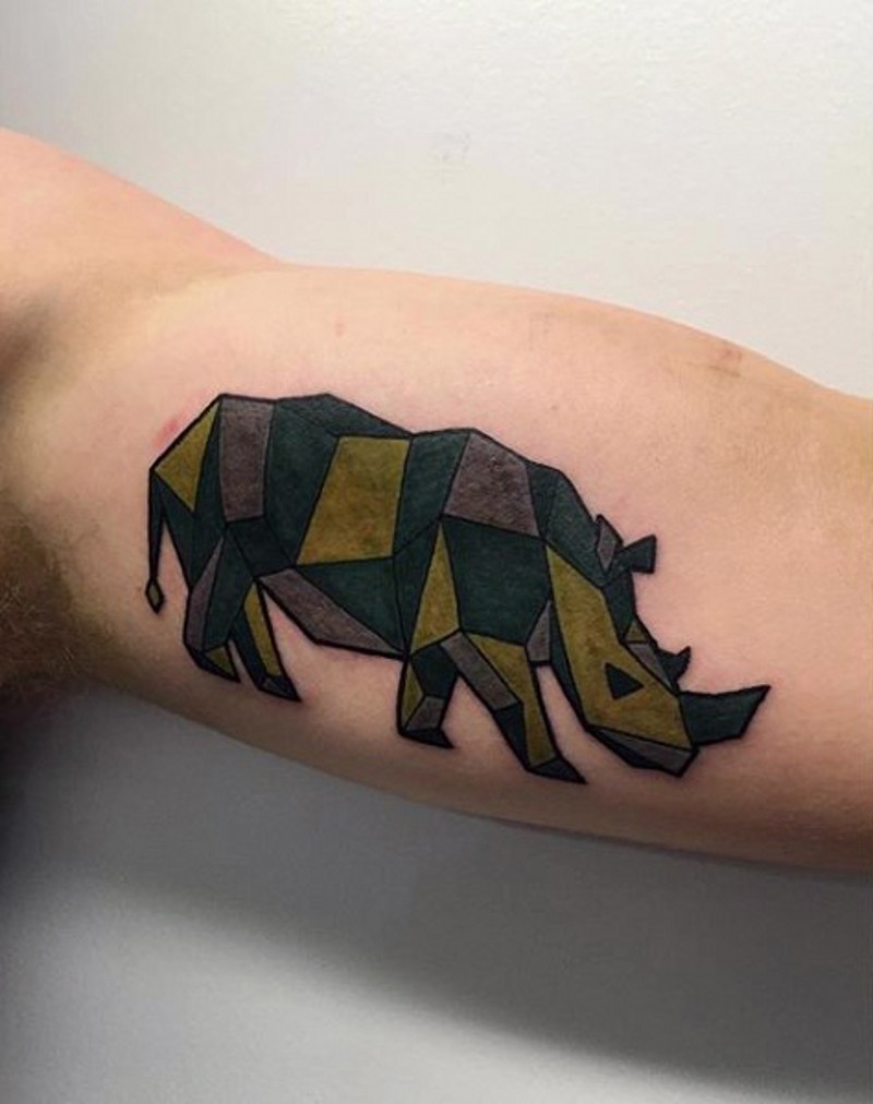Nashorn geformtes farbiges Tattoo am Bizeps im geometrischen Stil