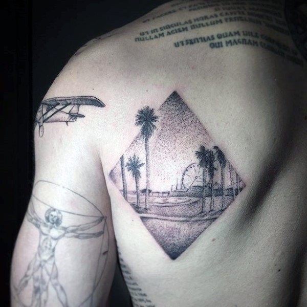Rhombus shaped dotwork style scapular tattoo of ocean beach with palm trees