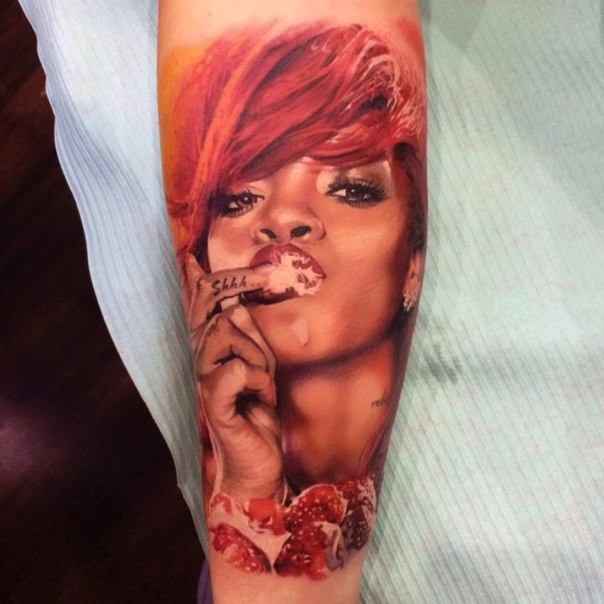 Rihanna colored portrait tattoo on arm
