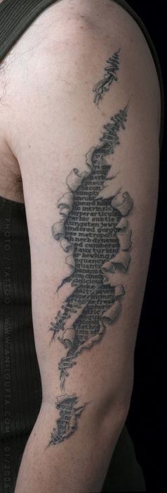 Ripped skin like black and white antic lettering tattoo on arm