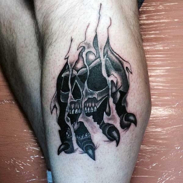 Ripped skin like black ink monster skull with claw tattoo on thigh