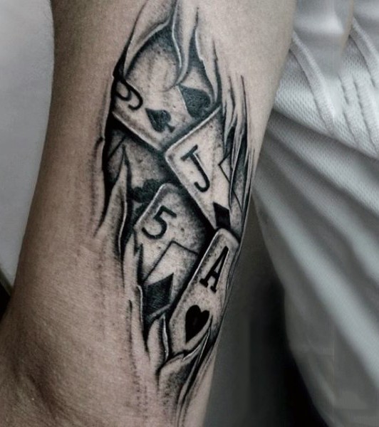 Ripped skin style black and white playing cards tattoo on arm