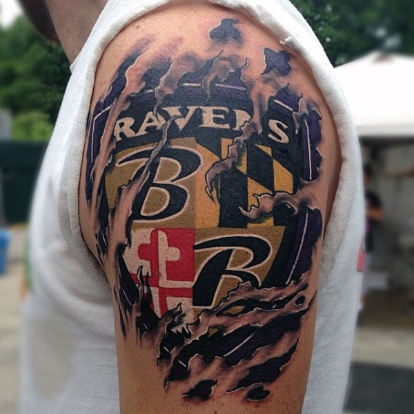 Ripped skin style colored shoulder tattoo of sports team emblem with lettering