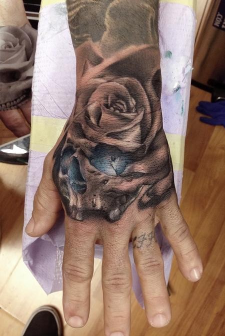 Black rose in skull tattoo by ryan mullins