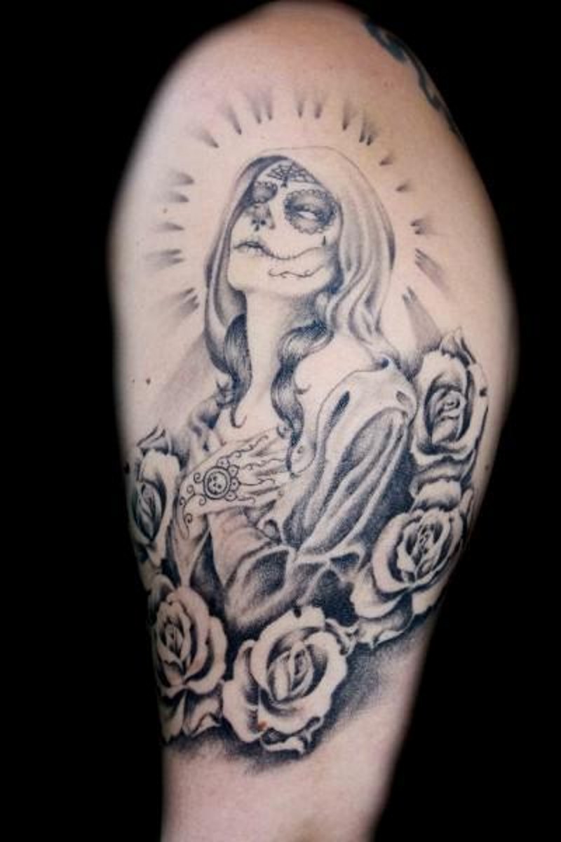 Tatuaje en el brazo, la santa muerte que reza entre flores