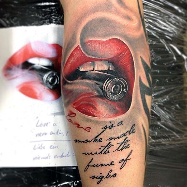 Seductive style painted cool lips with bullet and lettering tattoo on arm