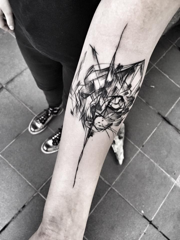Tatuaje de antebrazo de tinta negra separado de la cabeza de gato por Inez Janiak