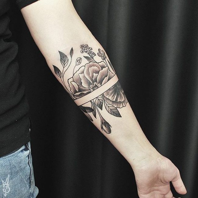 Separated black ink forearm tattoo of large flower