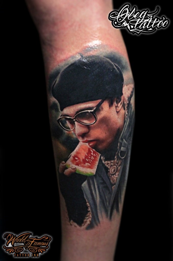 Tatuaje en la pierna, retrato realista de Sergei Bodrov que come una sandía