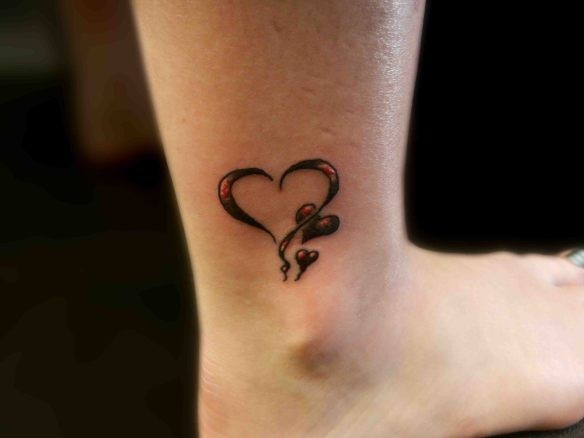 Tatuaje en el tobillo,  corazón con dos corazones pequeños, tinta negra