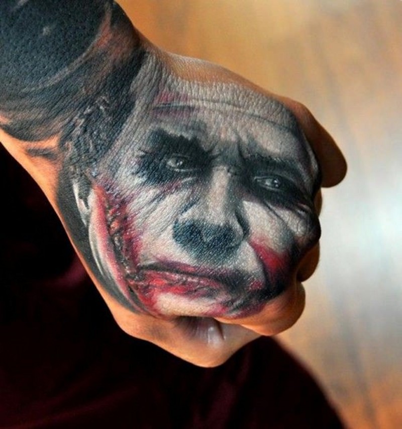 Sharp designed colored sad Joker face tattoo on fist