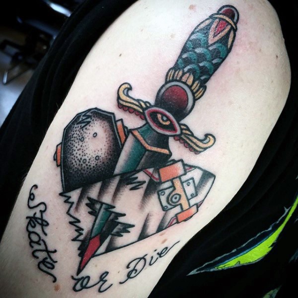 Sharp old school style dagger into skate board colored shoulder tattoo with lettering