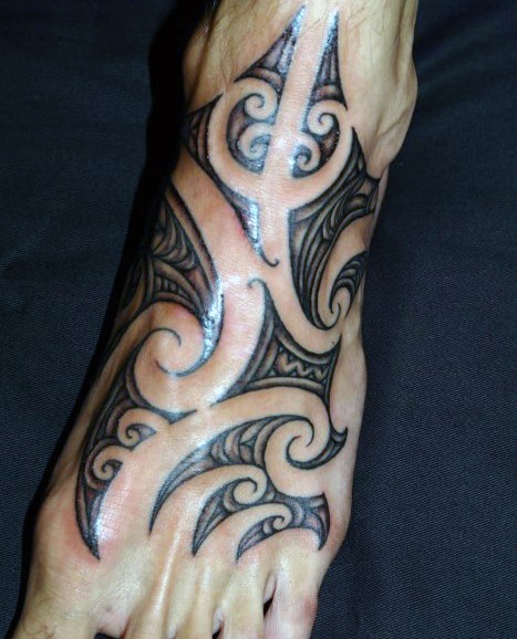 Sharp tribal style ornament black and white tattoo on foot