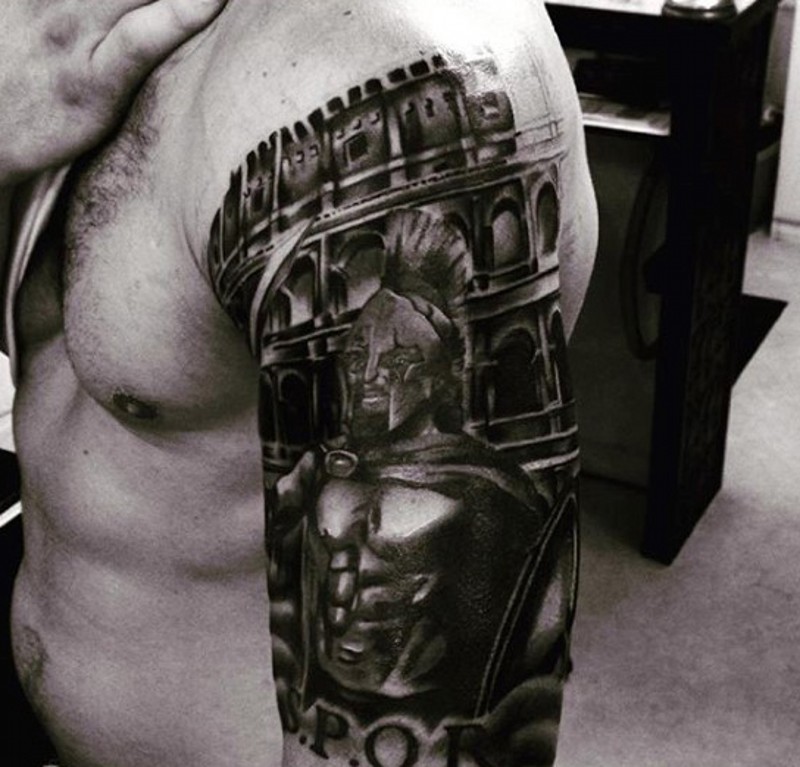 Shoulder placed black and white tattoo of Spartan warrior and Rome arena