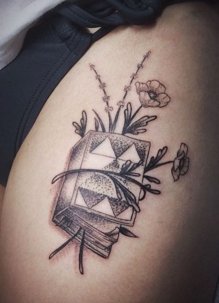 Tatuaje en el hombro,
libro grueso con flores marchitas