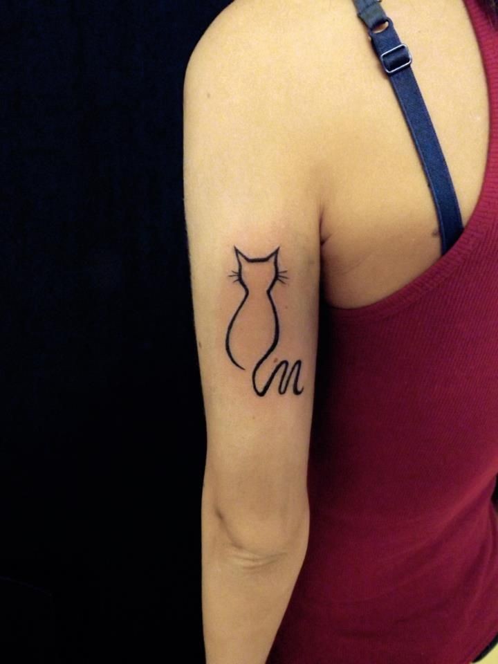 Tatuaje en el brazo de la silueta de una linea negra de un gato.