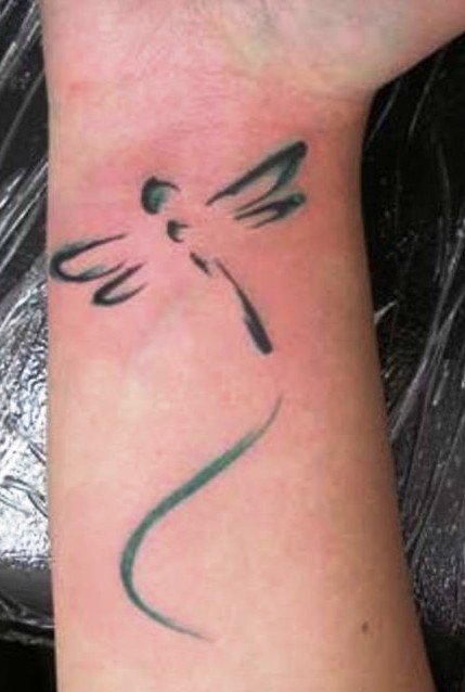 Silhouette einer Libelle Tattoo am Handgelenk