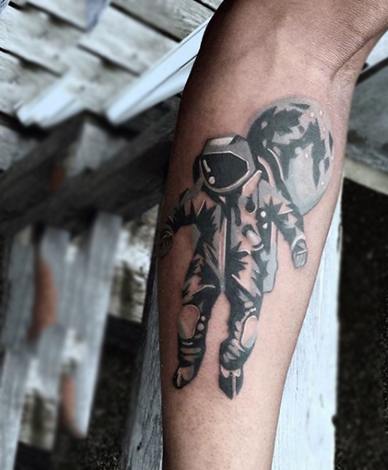 Tatuaje en el antebrazo,
astronauta en un traje espacial con globo