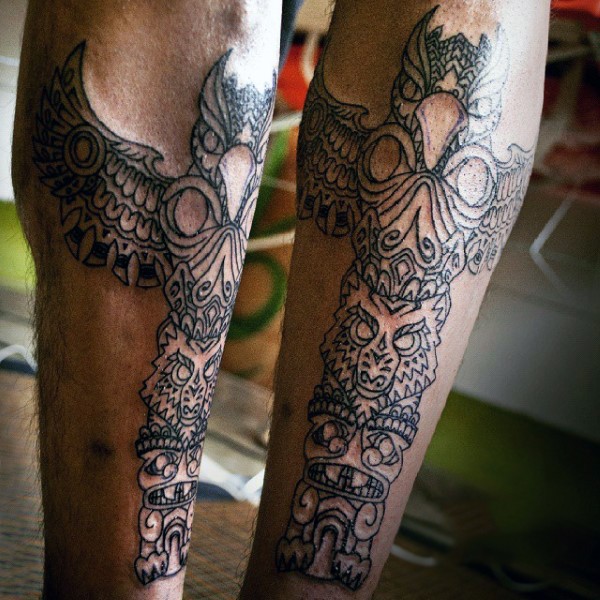 Simple black and white tribal statue tattoo on leg