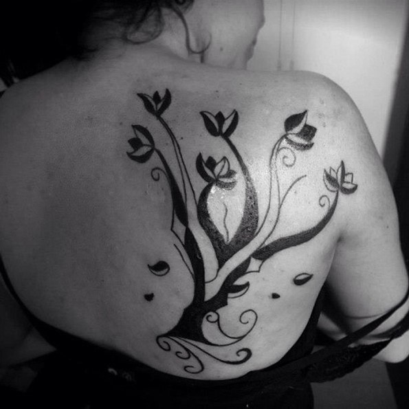 Simple black in tribal style tree tattoo on shoulder