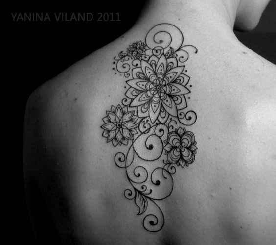 Simple black ink floral tattoo on upper back