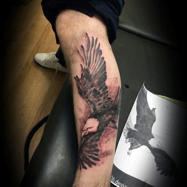 Simple black ink flying eagle tattoo on leg