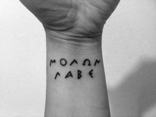 Einfaches schwarzes lateinisches Schriftzug Tattoo am Handgelenk