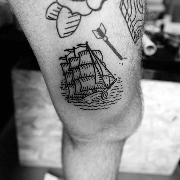 Simple black ink sailing ship tattoo on thigh