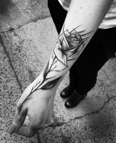 Simple black ink sketch style rose tattoo on wrist and hand