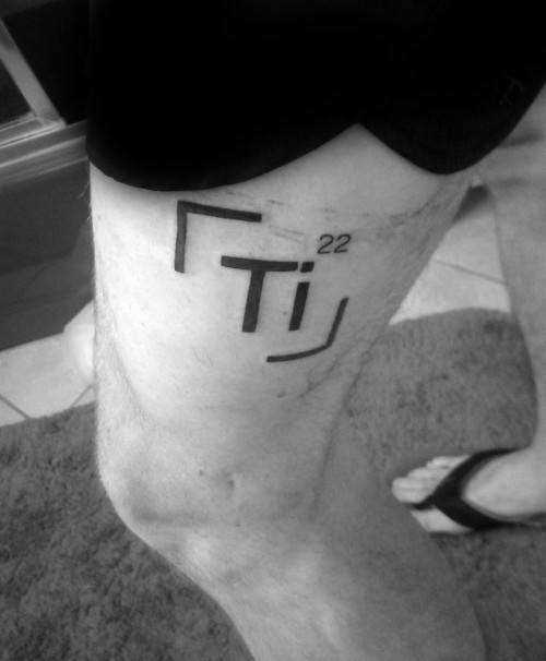 Simple black ink thigh tattoo of chemistry element