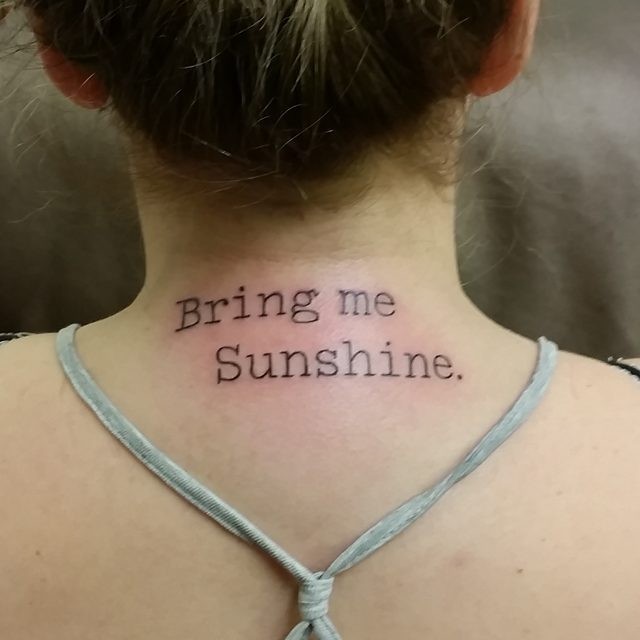 Simple black ink type writer font like lettering tattoo on neck