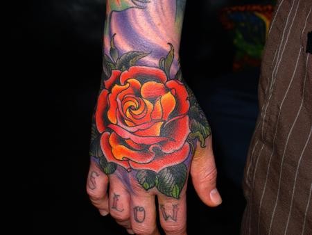Tatuaje en la mano, rosa tradicional hermosa