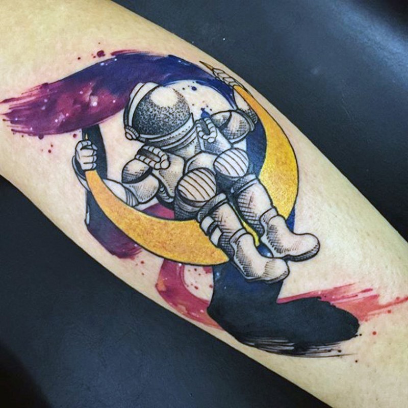 Tatuaje en el antebrazo, astronauta divertido que se siente en la luna