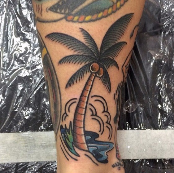 Simple colored little palm tree with coconuts tattoo on leg