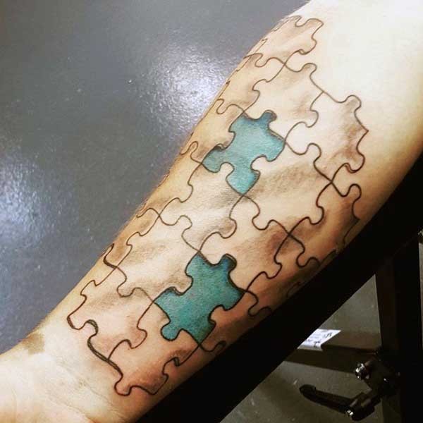 Simple colored puzzle picture tattoo on forearm