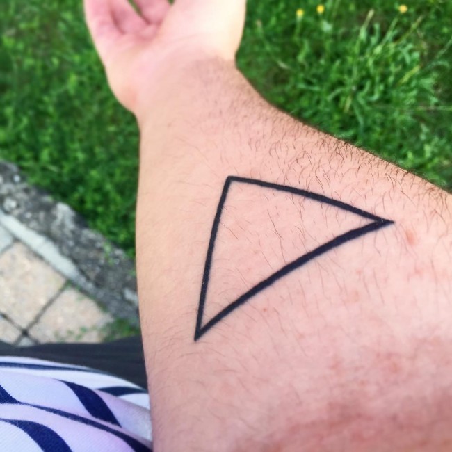 Simple design dark black ink triangle tattoo on forearm