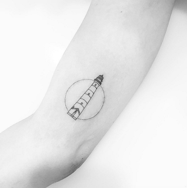 Simple design small size lighthouse in circle tattoo on biceps