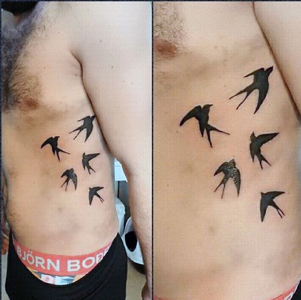 Simple designed and painted black ink flying birds tattoo on side