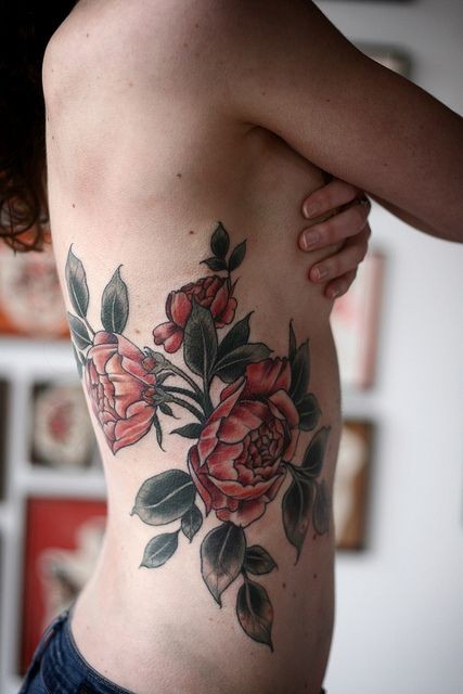 Simple designed and painted red colored flowers tattoo on side