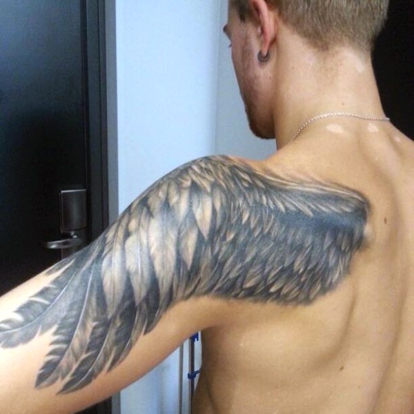 Simple designed big black and white feather wing tattoo on shoulder