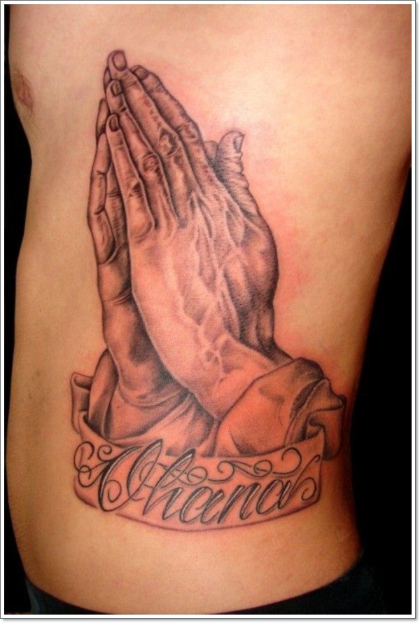 Simple designed big colored praying hands with lettering tattoo on back