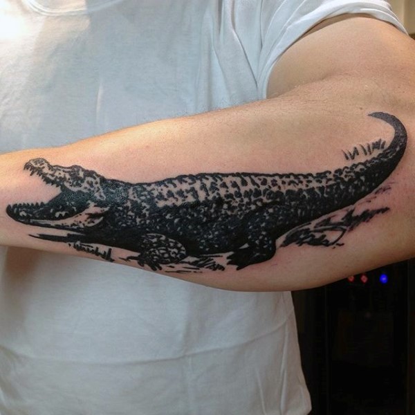 Simple designed black and white alligator tattoo on arm