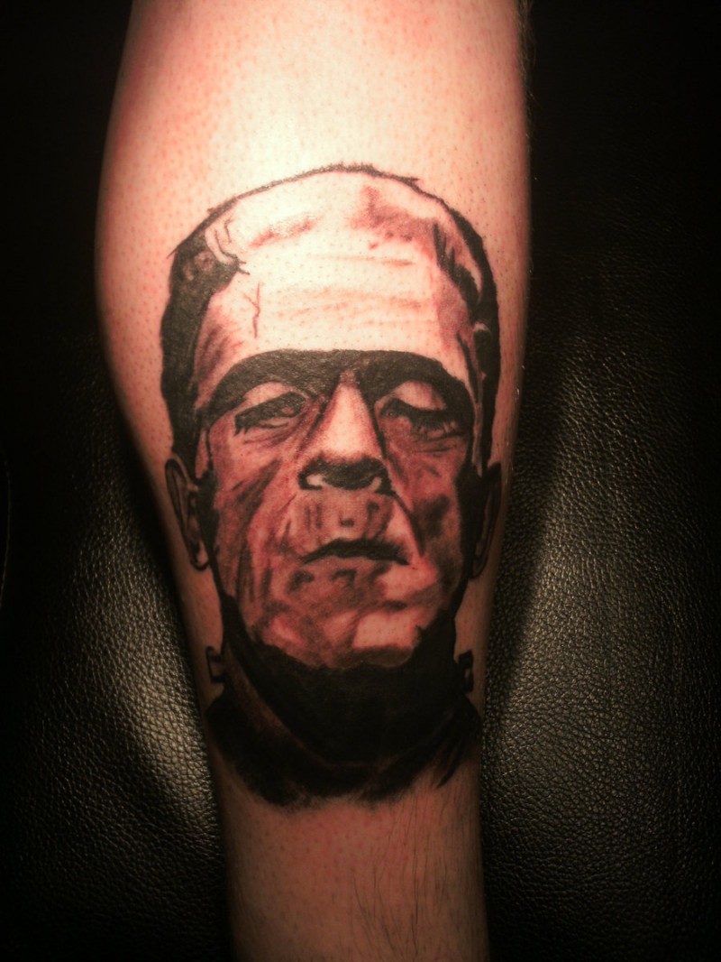 Simple designed black and white Frankenstein monster portrait tattoo on leg