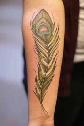 Tatuaje en el antebrazo, pluma verde de pavo real